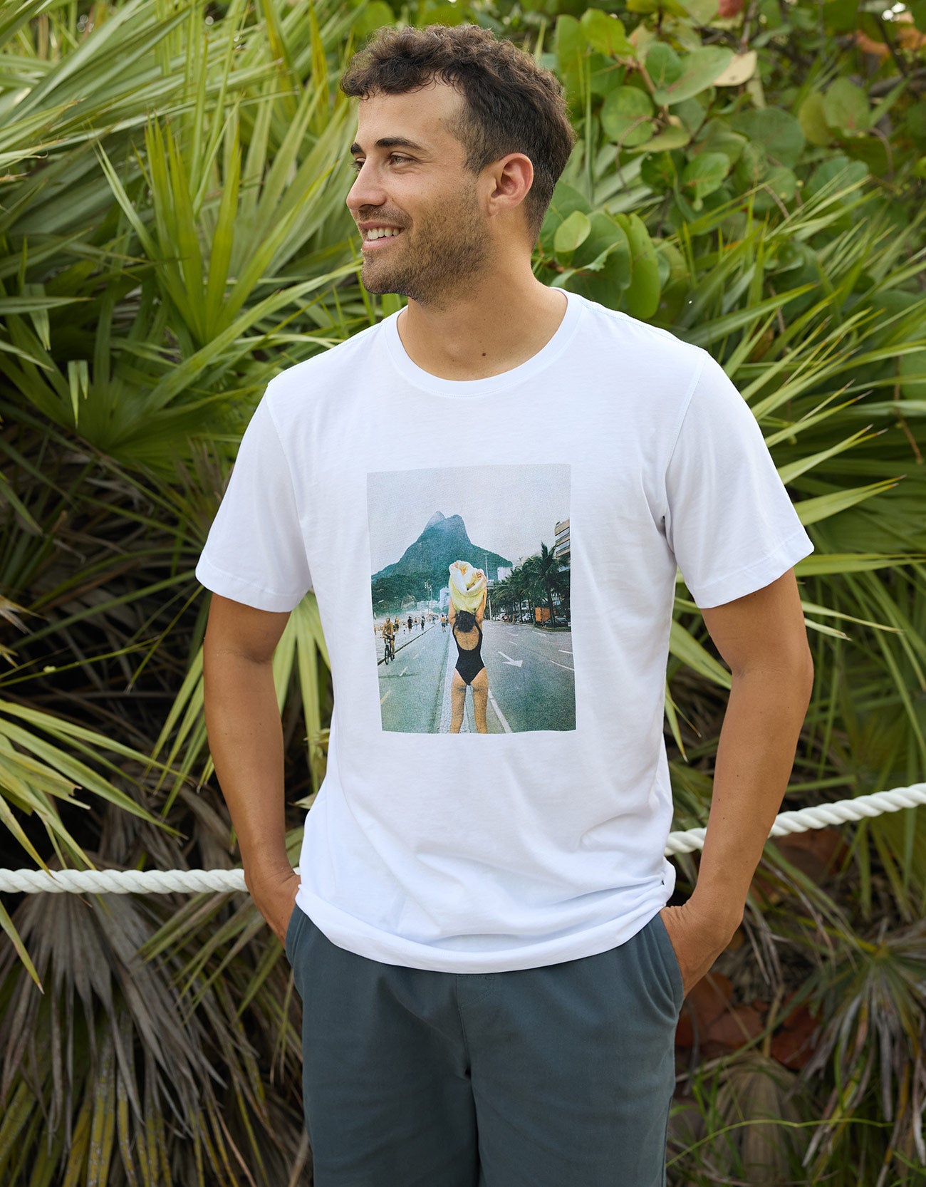 Baja Llama The Girl In Ipanema Primo Graphic Tee white short sleeve t-shirt worn by a smiling model outdoors.