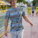 Smiling male model walking along a sunny outdoor boardwalk wearing The Good Ol’ Days patterned heavy tee by Baja Llama