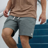 Baja Llama Too Easys Seafoam Green Stretch Cotton Shorts worn by a man walking down stairs