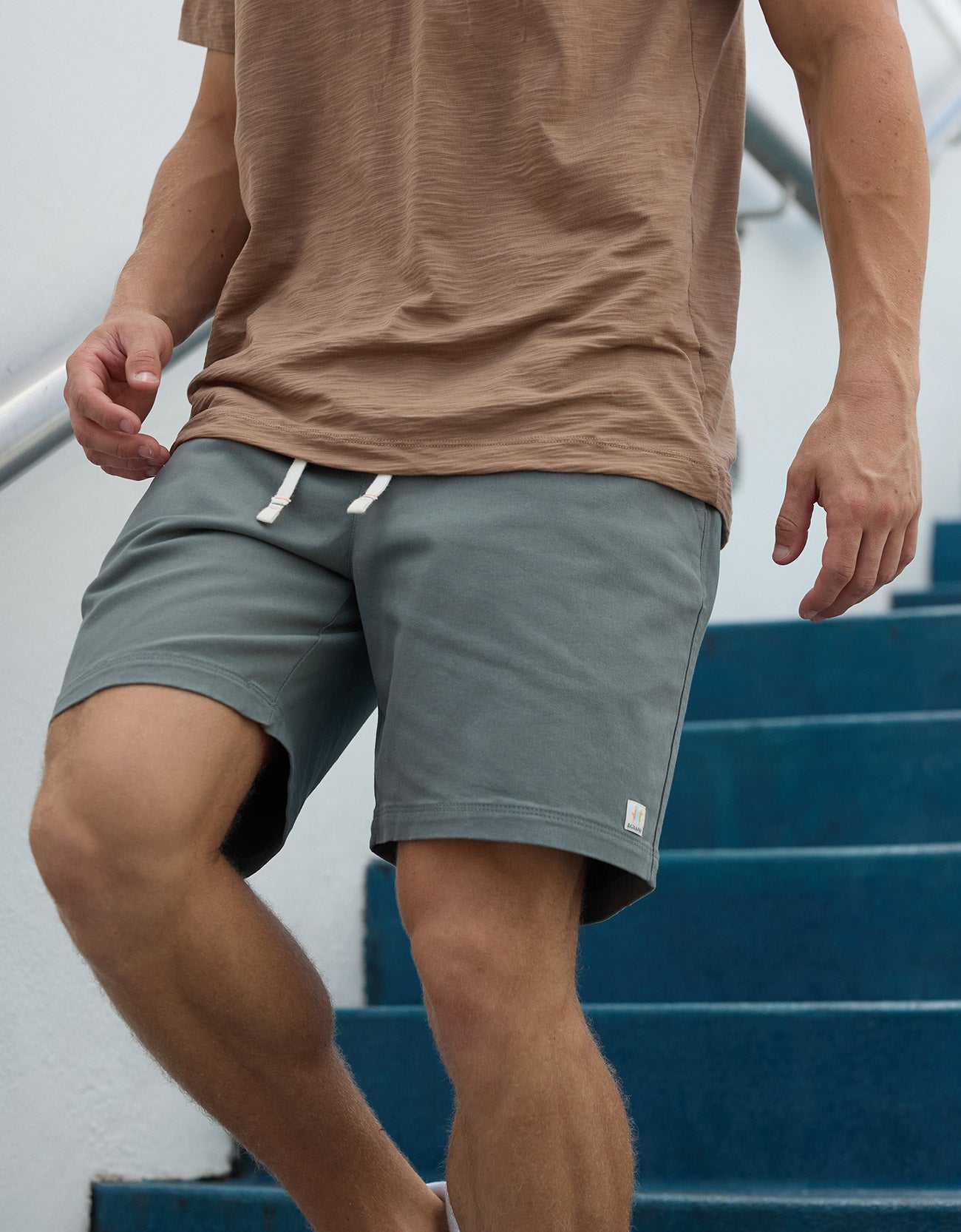 Baja Llama Too Easys Seafoam Green Stretch Cotton Shorts worn by a man walking down stairs