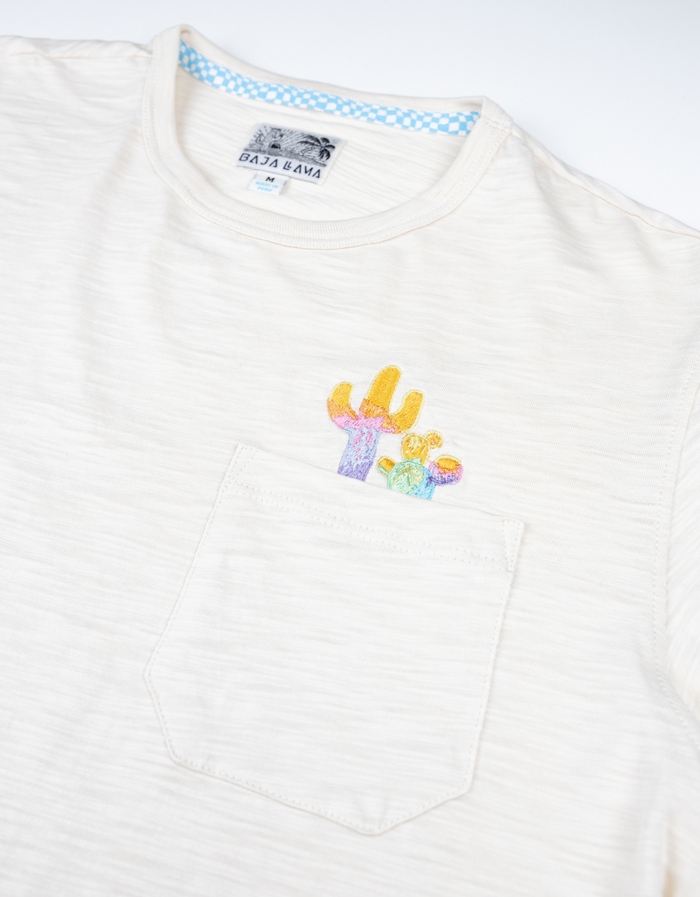 Detail view of the cream Colorful Cactus Slub Pima Pocket Tee by Baja Llama, highlighting the embroidered cactus logo.