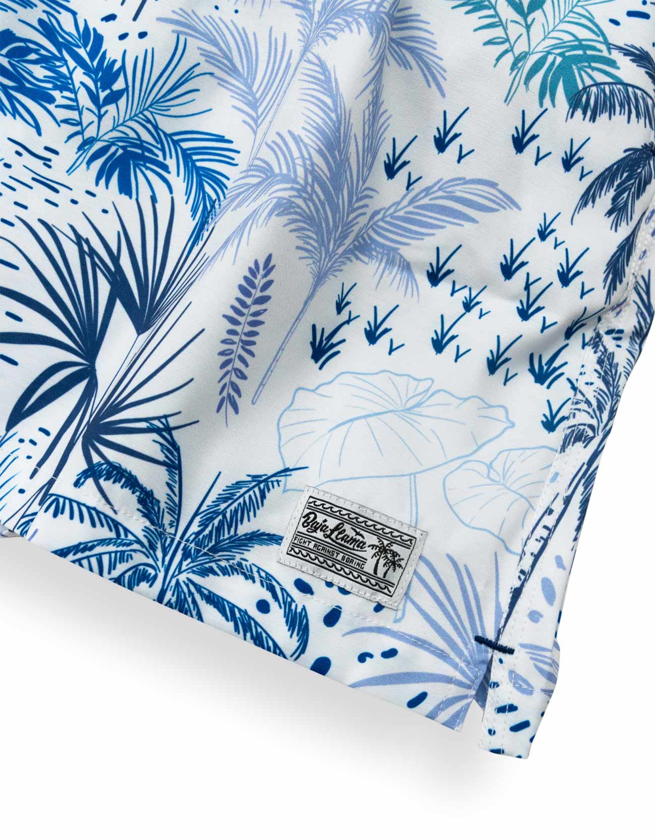 White men's swim trunks featuring tropical palm trees and taro in different hues of blue.